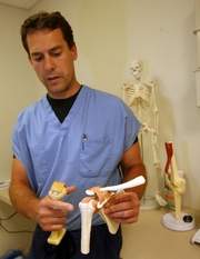 Dr. Andrew Willis, a surgeon with Tri-County Orthopaedic and Sports Medicine in Cedar Knolls, holds models of a shoulder that has been repaired, left, and one that is healthy at Atlantic Sports Health in Morristown, a specialized center for sports injuries.